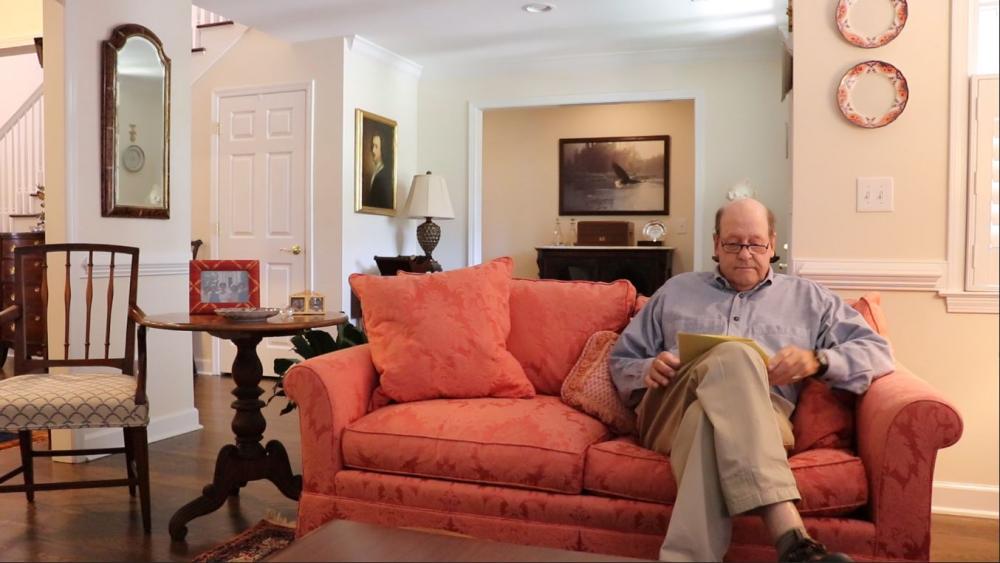 Ross Mackenzie on his couch reading his love note