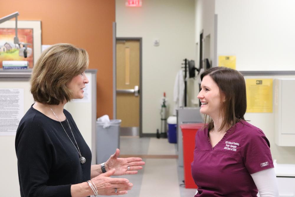 Kit Sullivan and Tonya Spangler chat in a dental clinic.