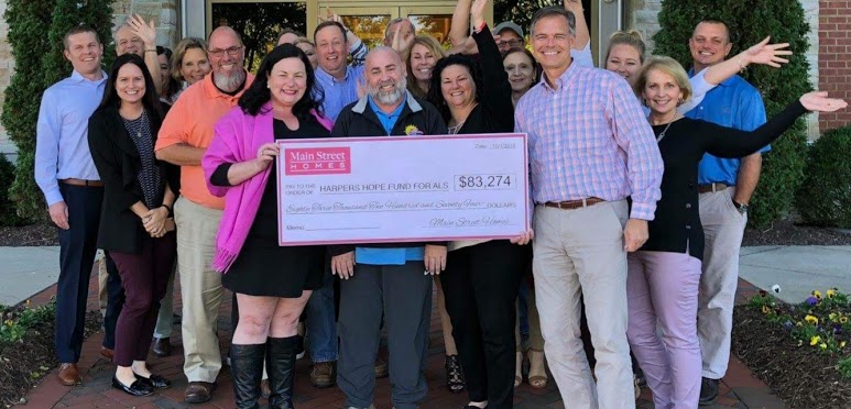 Vernon McClure (holding check on right), presents a check to support the Harper’s Hope Fund for ALS at VCU Health following the 2018 Main Street Homes Charity Golf Tournament. Funds raised at the tournament since 2017 have been raised and given in honor of Bobby Quinn (center). Photo courtesy of Bobby Quinn