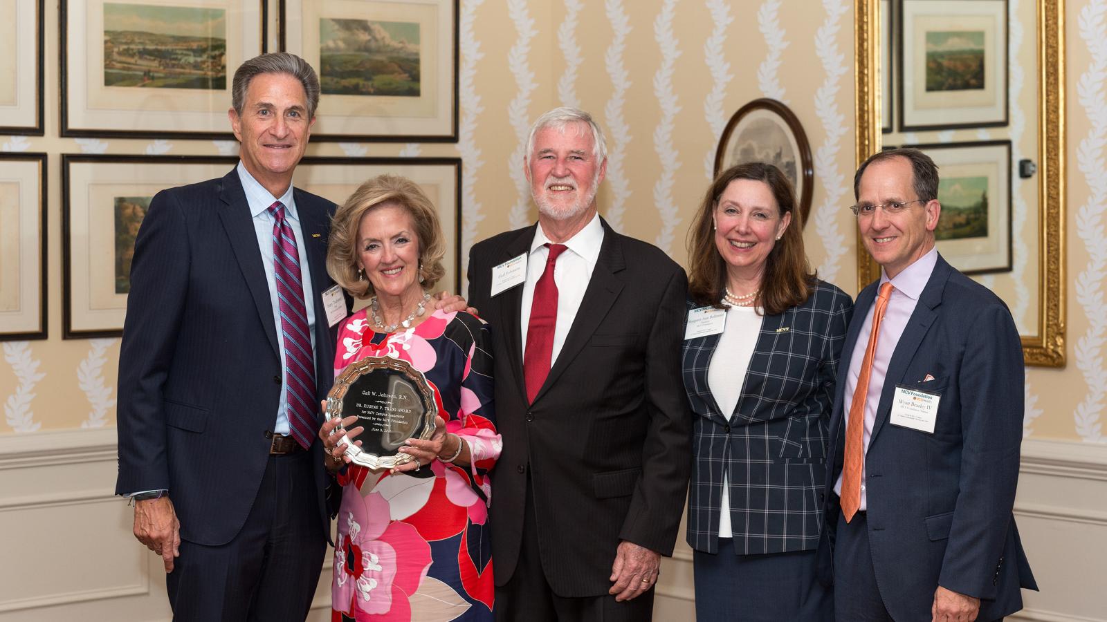 Gail Johnson, a former chair and current Lifetime Honorary Trustee of the MCV Foundation Board of Trustees, displays her Eugene P. Trani Award, which she received in recognition of her exceptional dedication and support of the MCV Campus. Harry Thalhimer, Earl Johnson, Margaret Ann Bollmeier and MCV Foundation Chair-Elect Wyatt Beazley IV congratulate her.